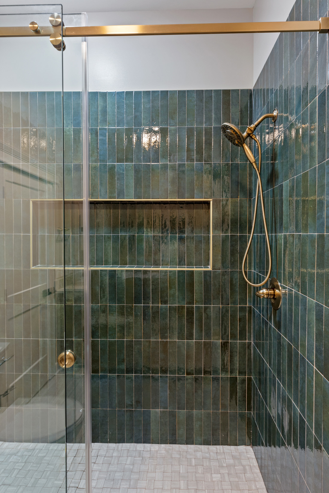 shower with emerald green tile and gold fixtures